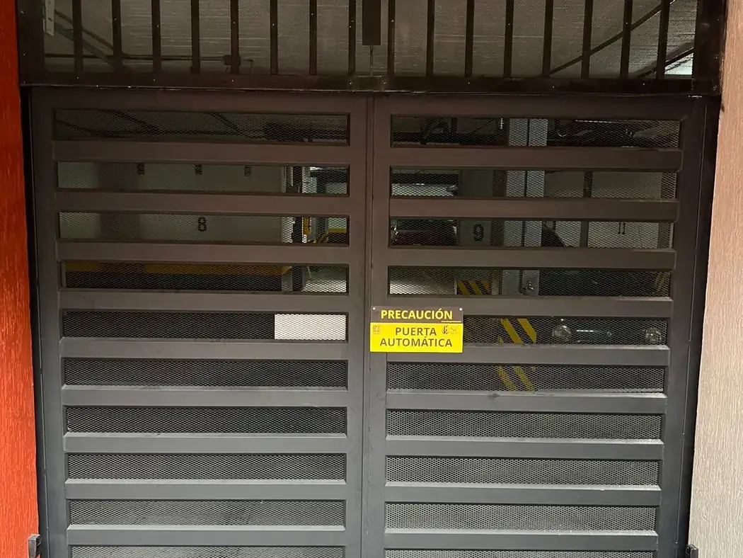 Puerta vehicular automatizada del sótano con aviso de precaución