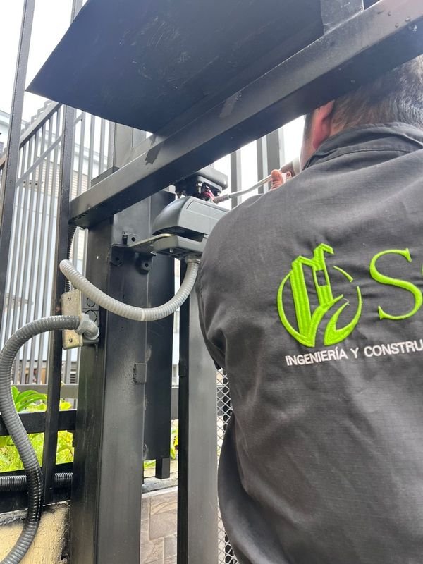 Técnico de SC Ingeniería instalando el operador de la puerta vehicular